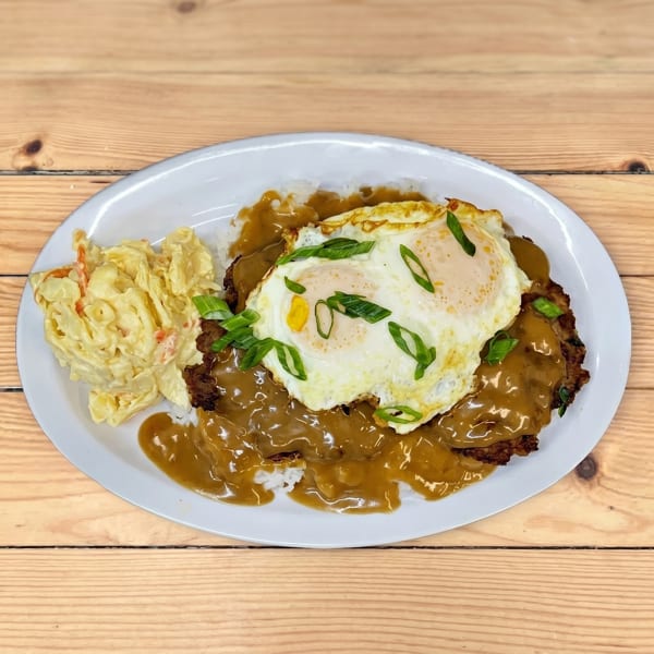 Loco Moco with two fried eggs, gravy, rice, and macaroni salad on a white plate.